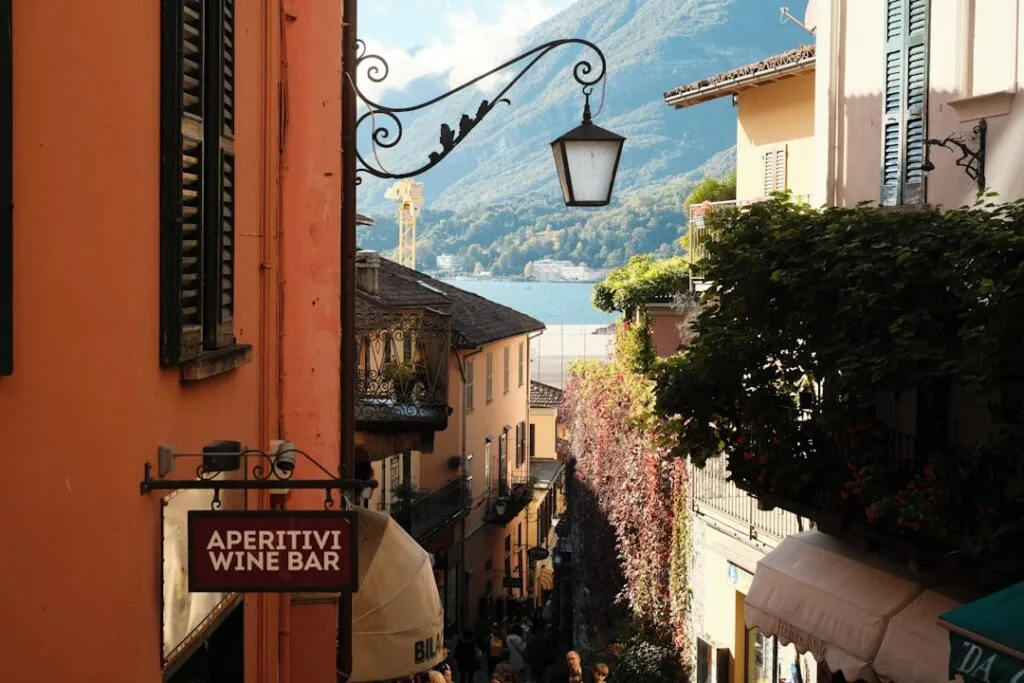 Enge Gasse mit Weinbar-Schild und Blick auf den Comer See
