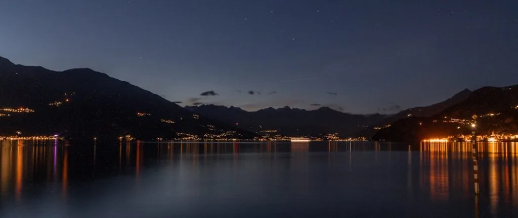 Panorama nocturne du Lac come avec reflets de lumières sur l'eau