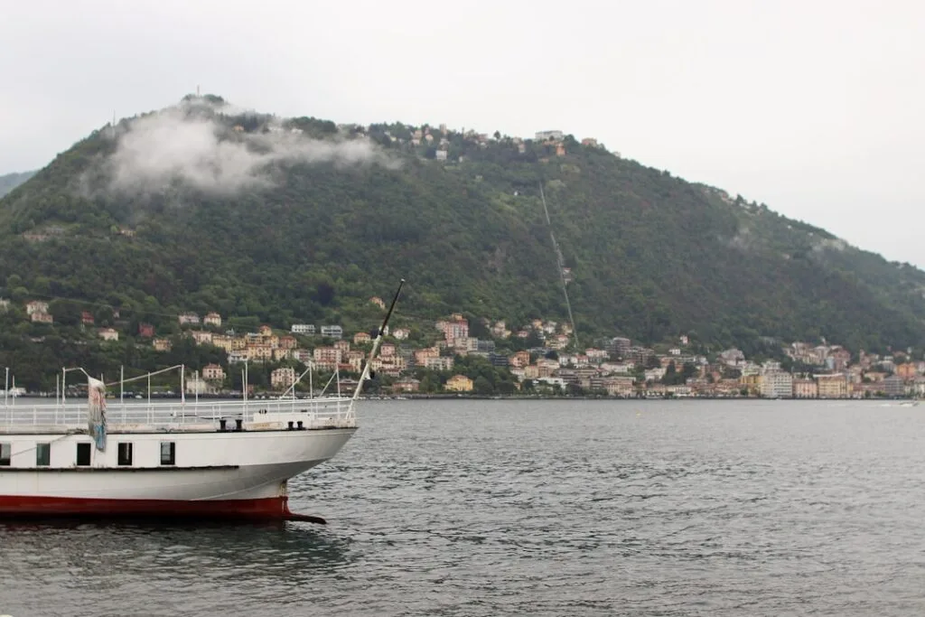 Passagierschiff am Comer See mit Häusern am gegenüberliegenden Hügel