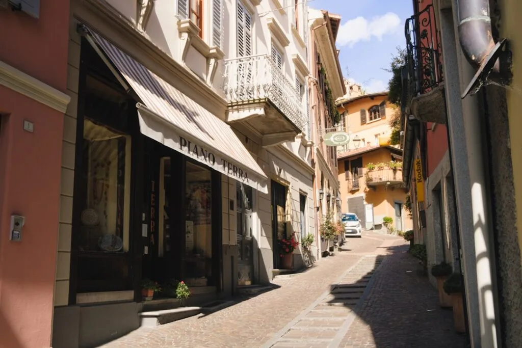 Enge Gasse mit Markise 'Piano Terra' und Balkonen in Menaggio