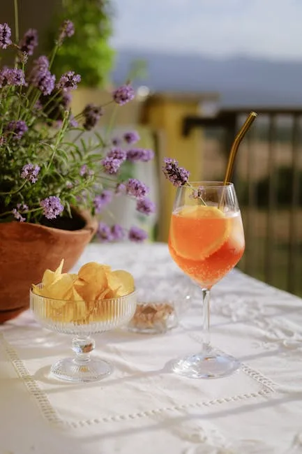 Spritz et chips sur une table de terrasse avec vue sur le Lac de Côme