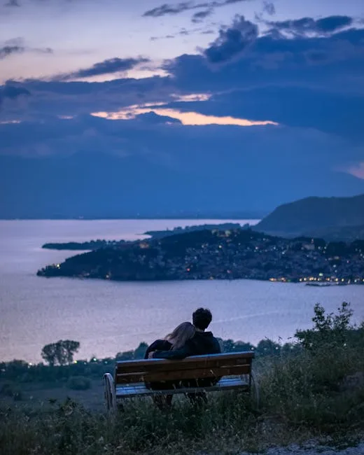 Couple enlacé sur un banc contemplant les lumières du Lac come.