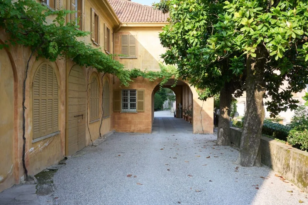 Cortile di villa storica con arco, persiane e viti vicino al Lago di Como
