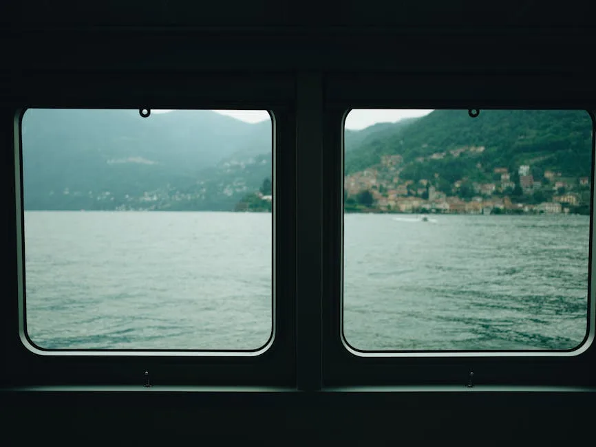 Blick durch Bootsfenster auf den Comer See und Ufer