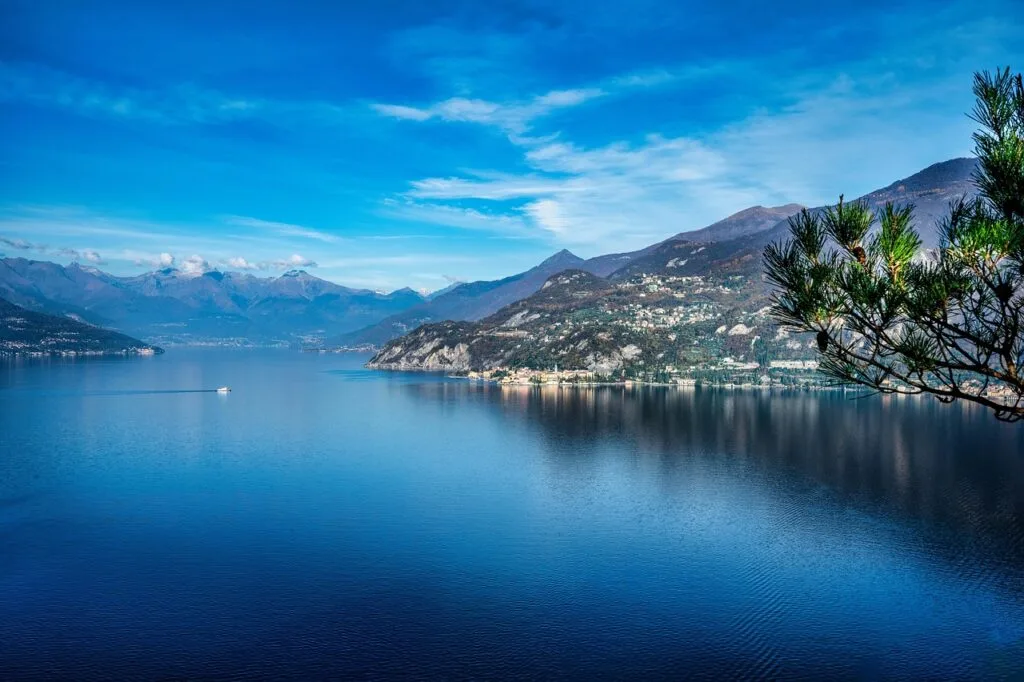 Étendue calme du Lac de Côme avec village côtier et collines