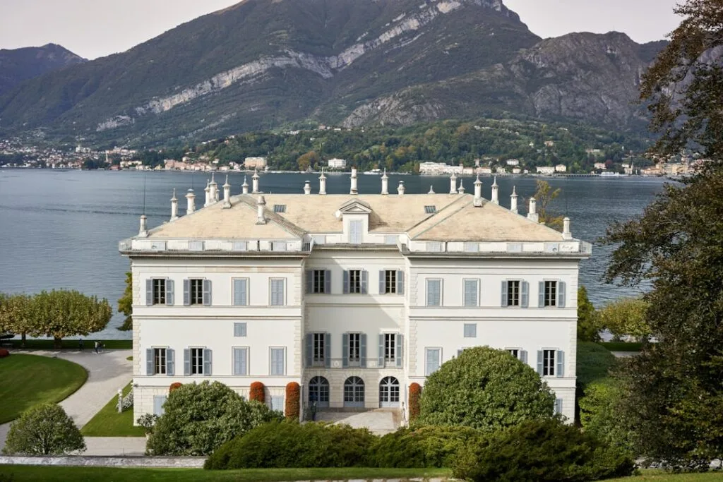 Villa blanche élégante au bord du Lac de Côme, montagnes en arrière-plan