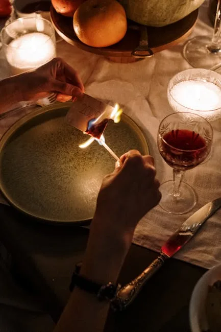 Hände zünden mit Streichholz Papier an, Teller, Kerzen und Rotwein
