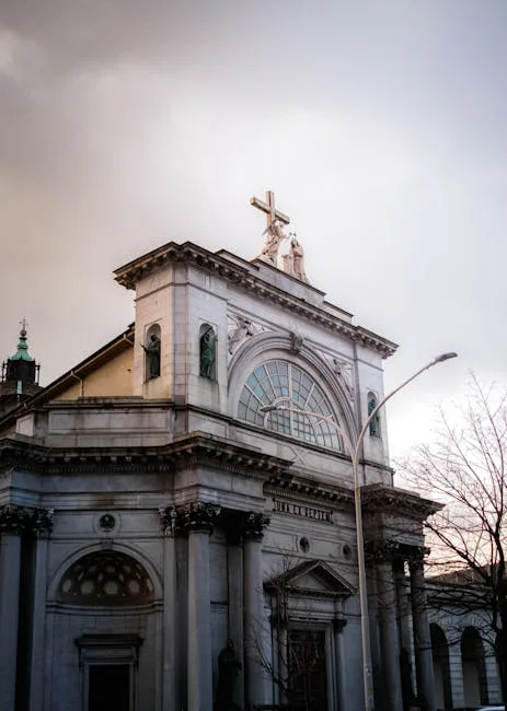 Fassade einer klassizistischen Kirche in Como mit Statue und Kreuz an der Spitze