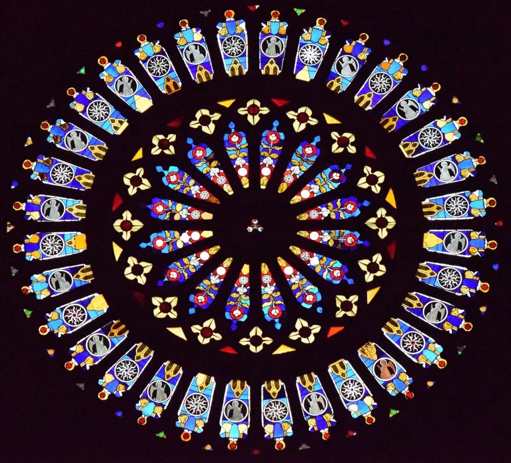 Rosace en vitrail aux motifs colorés illuminée sur fond sombre