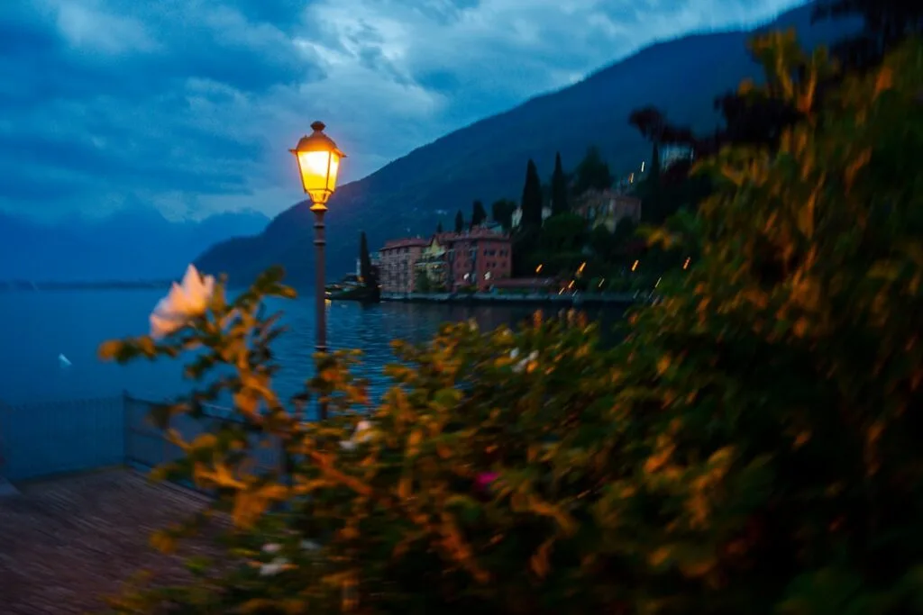 Abendliche Straßenlaterne am Ufer des Lac come, verschwommene Blumen