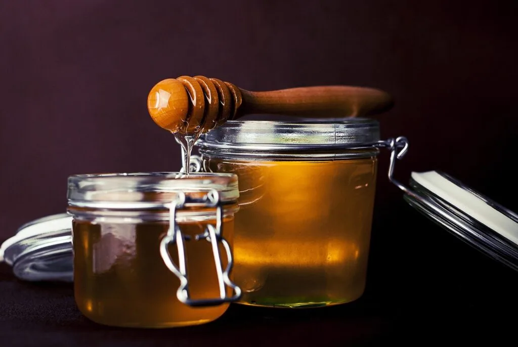 Gläser mit goldenem Honig und einer tropfenden Holzkelle, Comer See