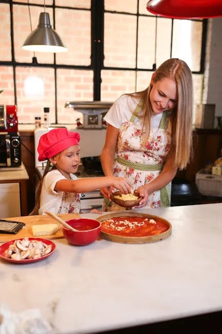 Mutter und Kind belegen gemeinsam Pizza auf Küchentheke