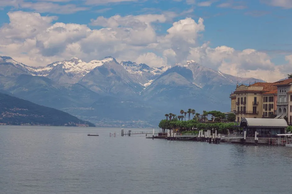 Façades d'hôtels et jetées bordant le lac de Côme, montagnes enneigées.