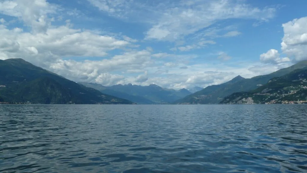 Ampia veduta del Lago di Como con montagne e cielo nuvoloso sullo sfondo