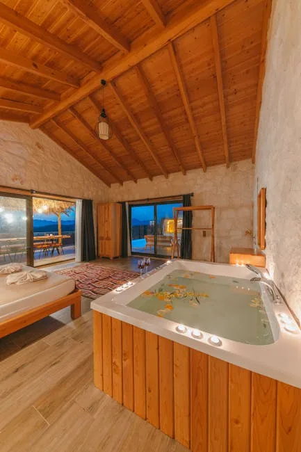 Rustikales Zimmer mit Whirlpool, Holzbalkendecke und Blick auf Lac come
