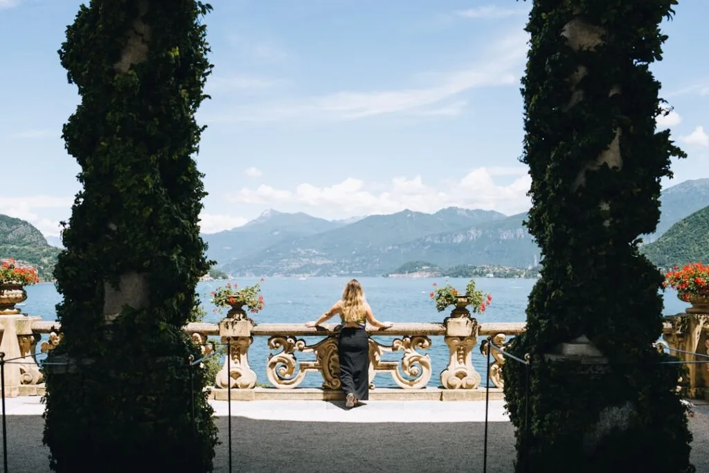 Person steht an Balustrade und blickt über den Comer See.