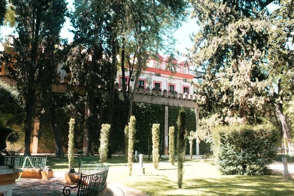 Schattenreiche Gärten mit Bänken und rosa Fassade am Comer See