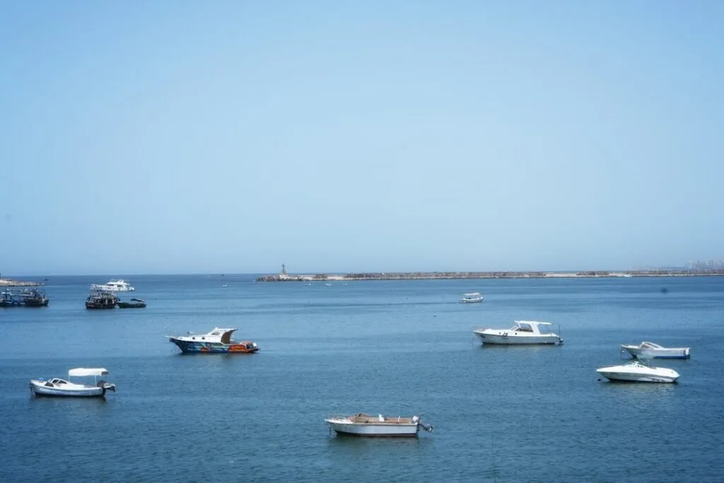 Several small boats anchored on calm blue water under clear sky