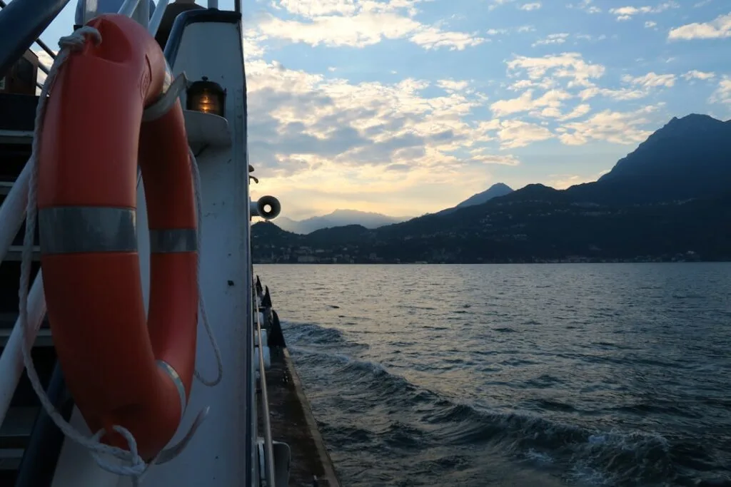 Lifebuoy on ferry railing with Lake Como mountains at sunset