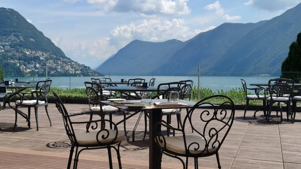 Terrasse de restaurant vide avec tables, vue sur le Lac de Côme