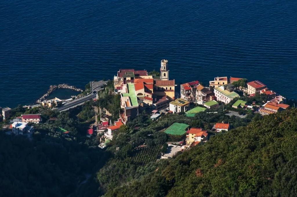 Cyclists along Menaggio coastline near a small village