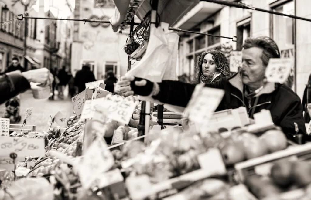 Vendeurs au marché de rue de Côme échangeant monnaie et paniers
