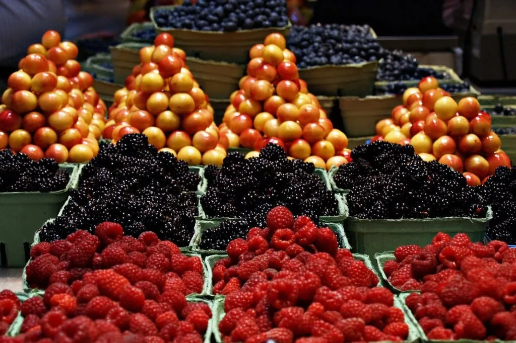Barquettes de framboises, mûres et mirabelles alignées au marché du Lac de Côme