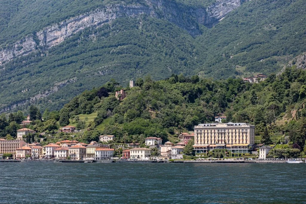 Uferort am Comer See mit historischem Hotel und bewaldeten Hügeln